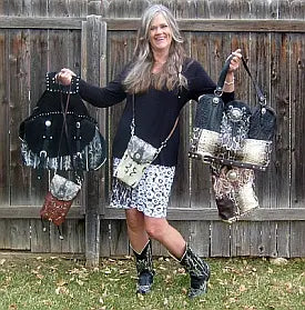 chris thompson holding multiple handbags in front of a wooden fence