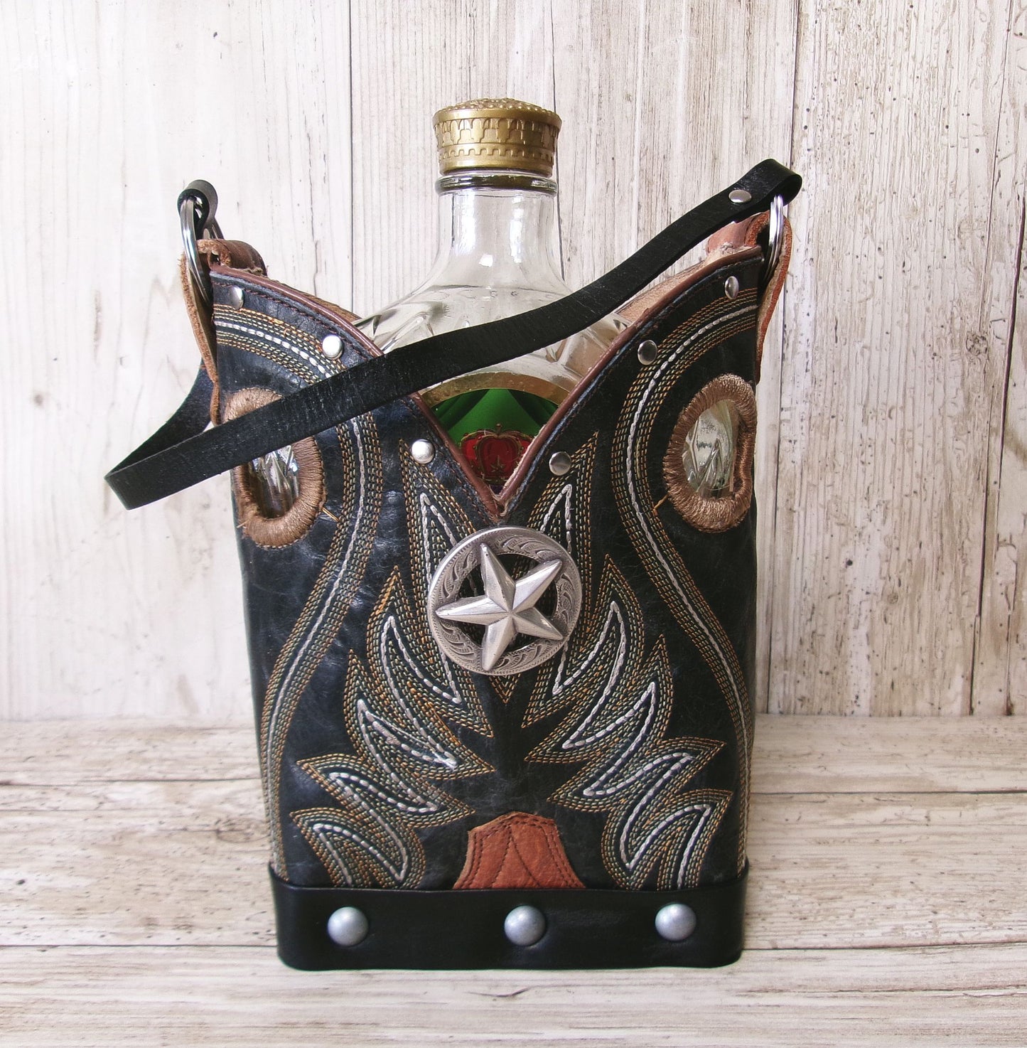 Cowboy boot-shaped bottle holder with star design on a wooden surface