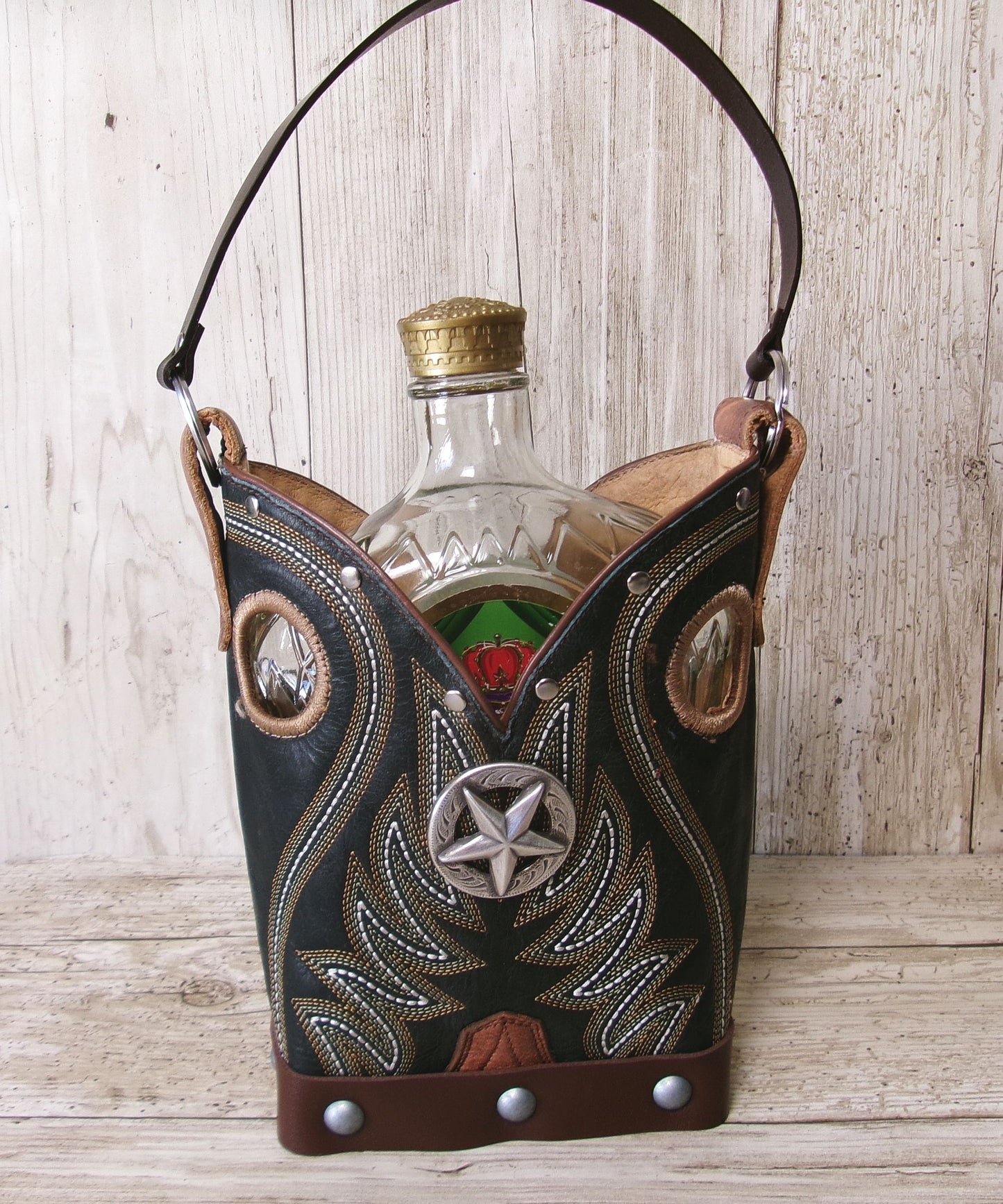 Decorative leather bottle holder with a bottle inside on a wooden surface