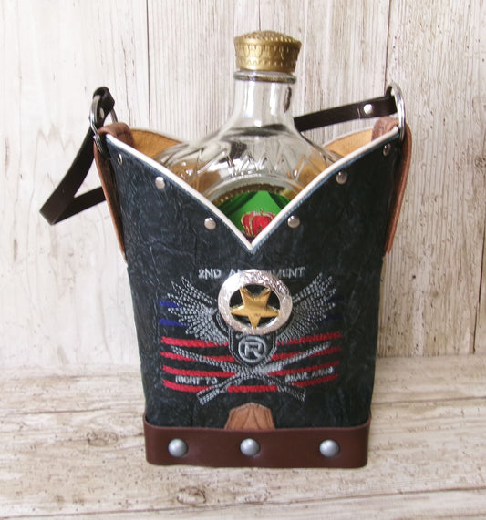 Denim cooler bag with embroidered design holding a bottle on a wooden surface
