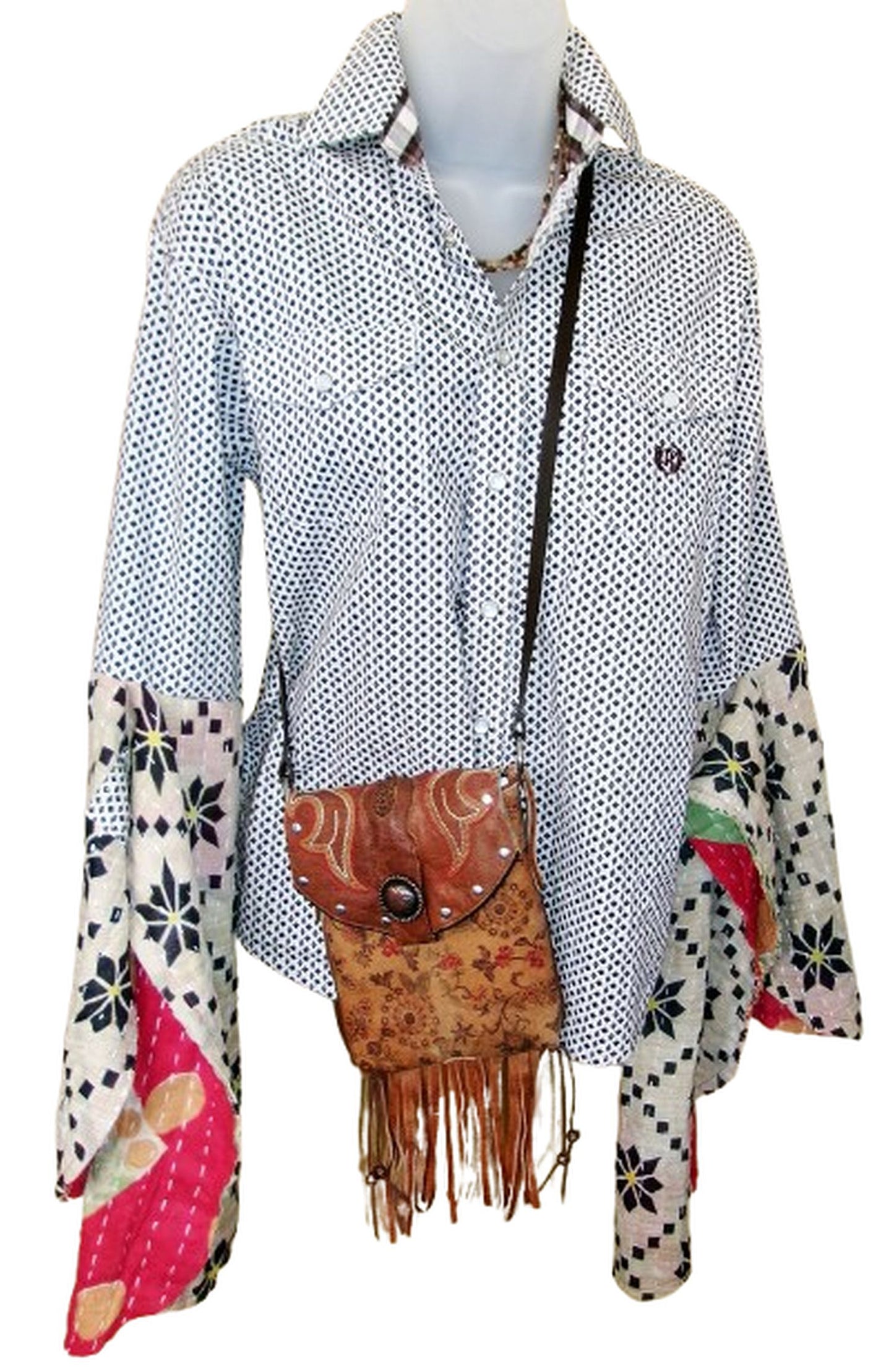 Mannequin wearing a patterned shirt with a brown leather bag featuring fringe details.