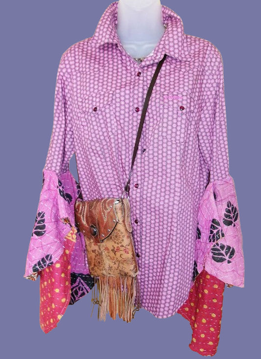Pink patterned shirt with floral accents on a mannequin against a purple background