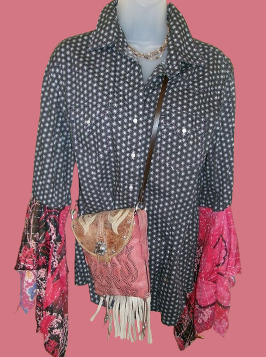 Mannequin wearing a polka dot shirt with colorful sleeves and a pink purse on a pink background