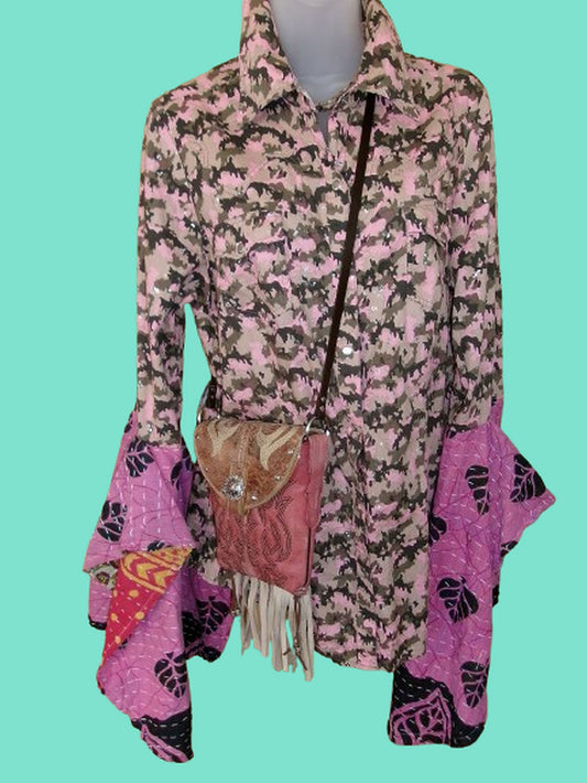 Mannequin wearing a pink and black patterned jacket with a matching bag on a teal background