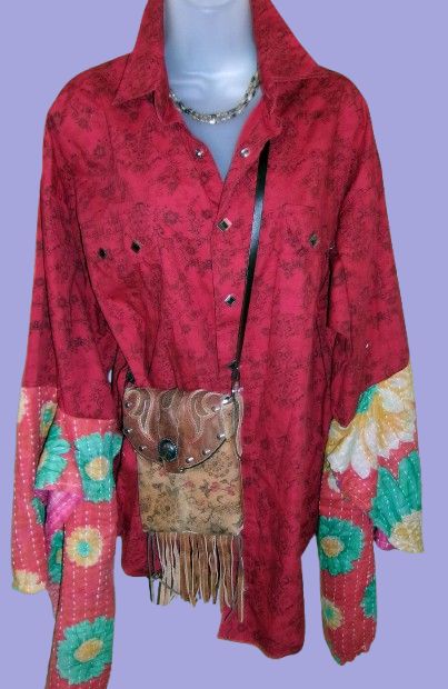 Red floral-patterned jacket with a matching handbag on a mannequin against a purple background