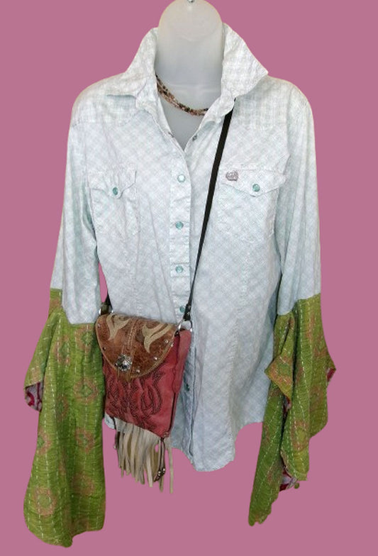 Mannequin wearing a white shirt with green accents and a red bag on a pink background