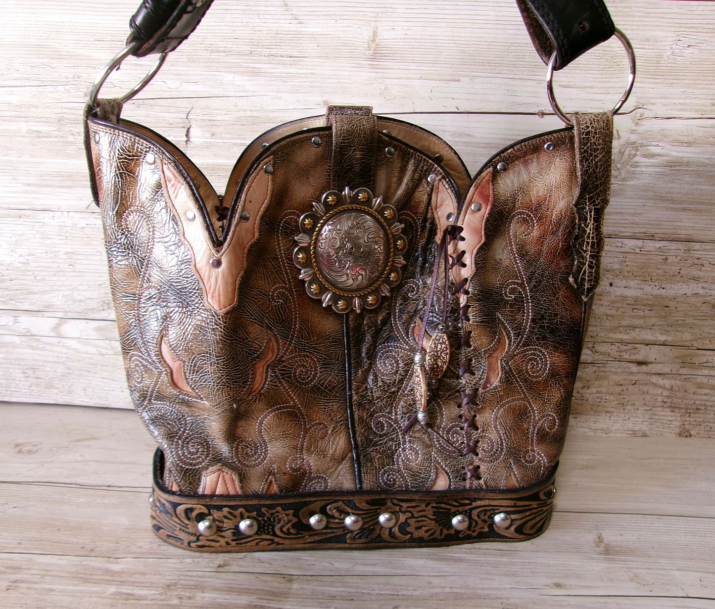 Decorative leather bag with intricate designs on a wooden surface