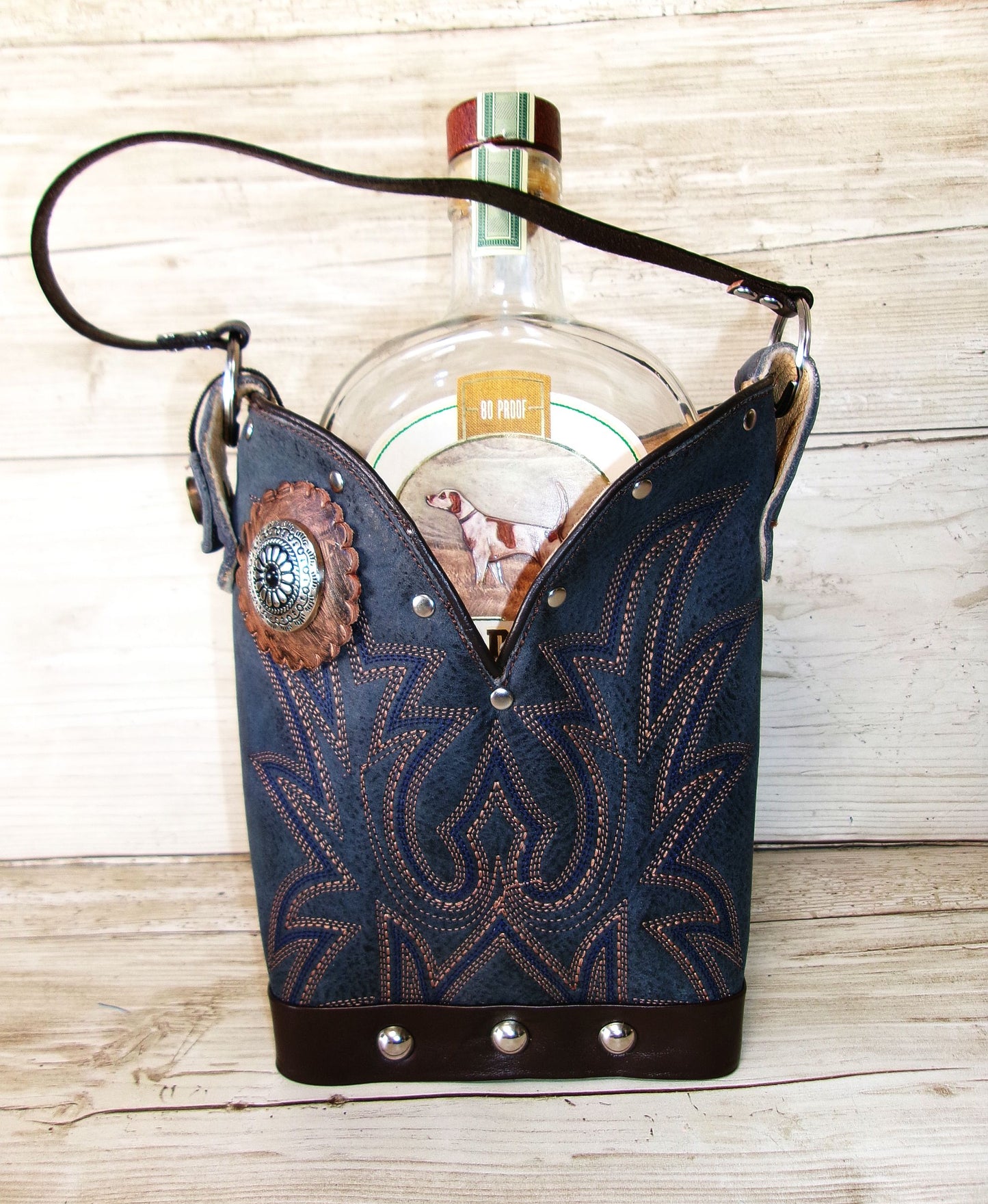 Cowboy boot-shaped bottle holder with a bottle inside on a wooden surface
