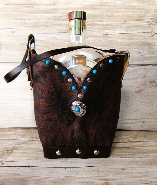 Brown leather handbag with decorative studs on a wooden surface