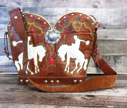 Brown leather bag with horse and star designs on a wooden surface