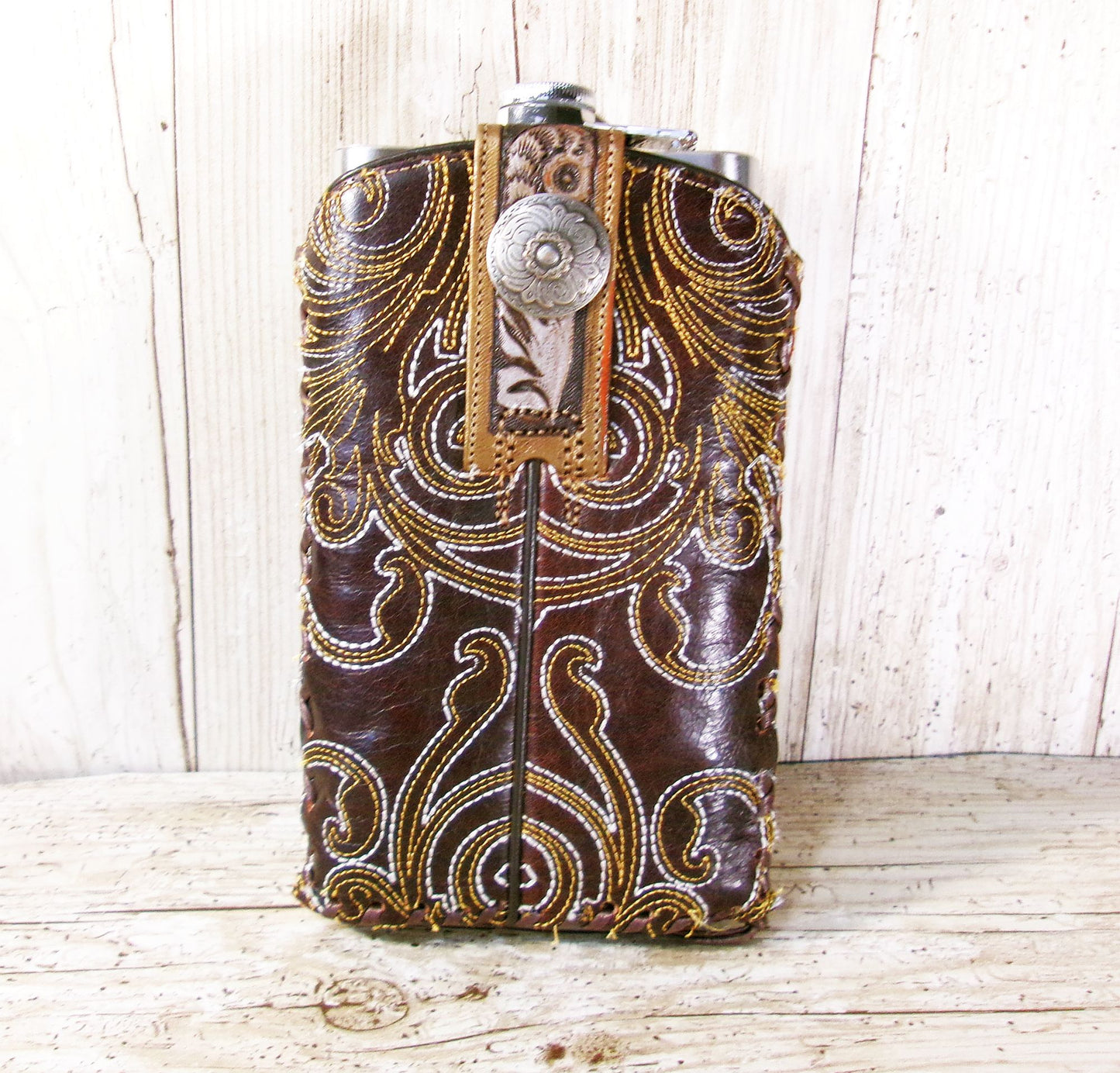 Decorative leather flask with intricate patterns on a wooden surface