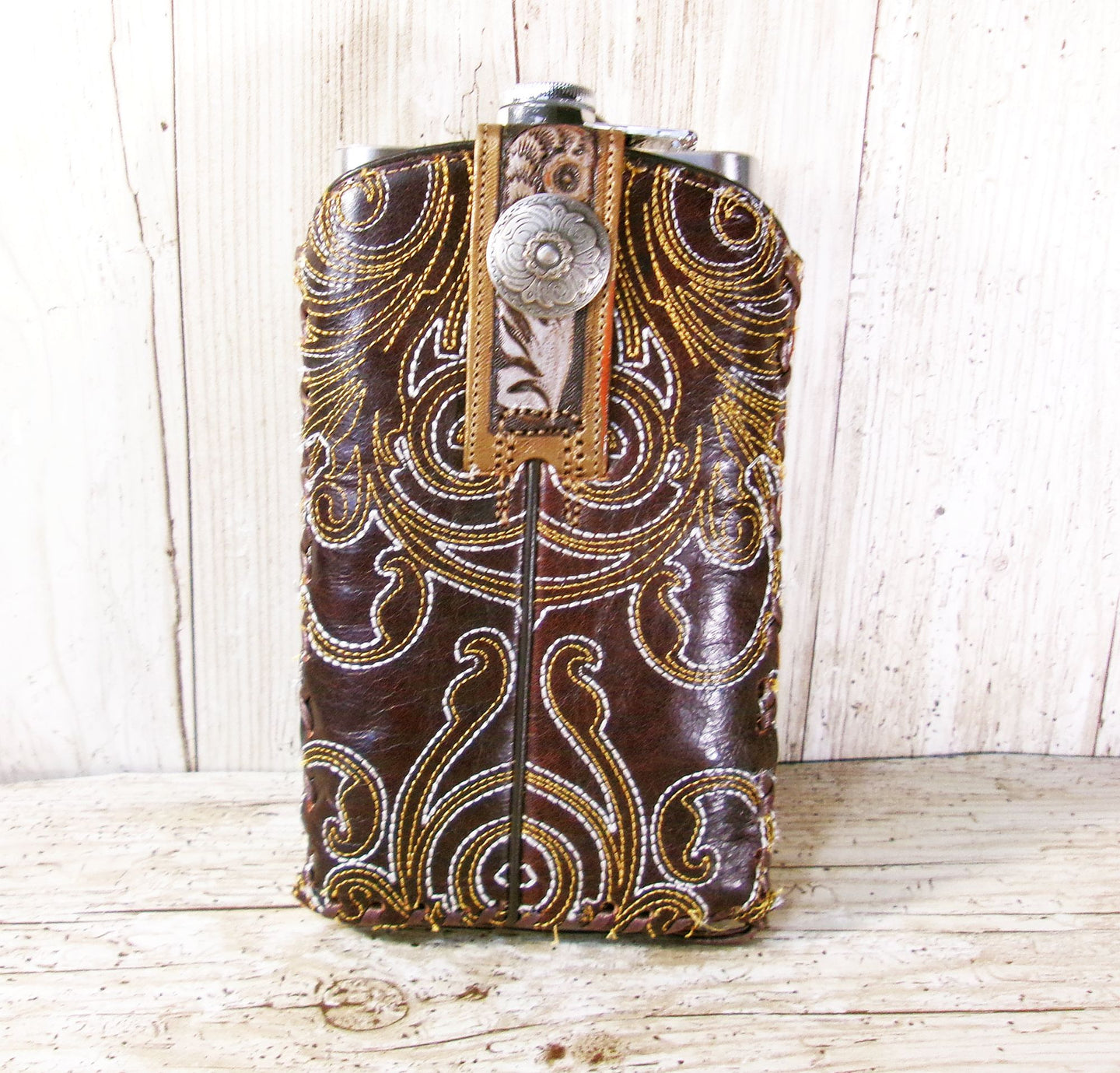 Decorative leather flask with intricate patterns on a wooden surface