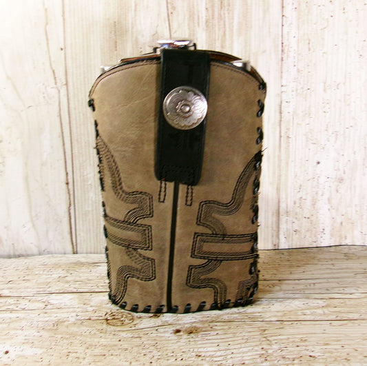 Brown leather flask with black accents and a silver cap on a wooden surface.