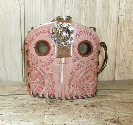 Pink leather case with decorative metal clasp on a wooden surface