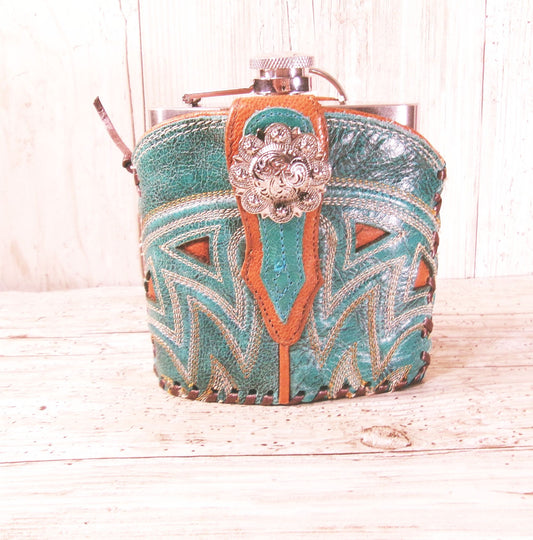 Decorative flask with intricate patterns and a decorative clasp on a wooden surface.