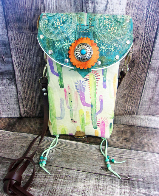 Colorful handbag with floral design and orange flower on a wooden surface
