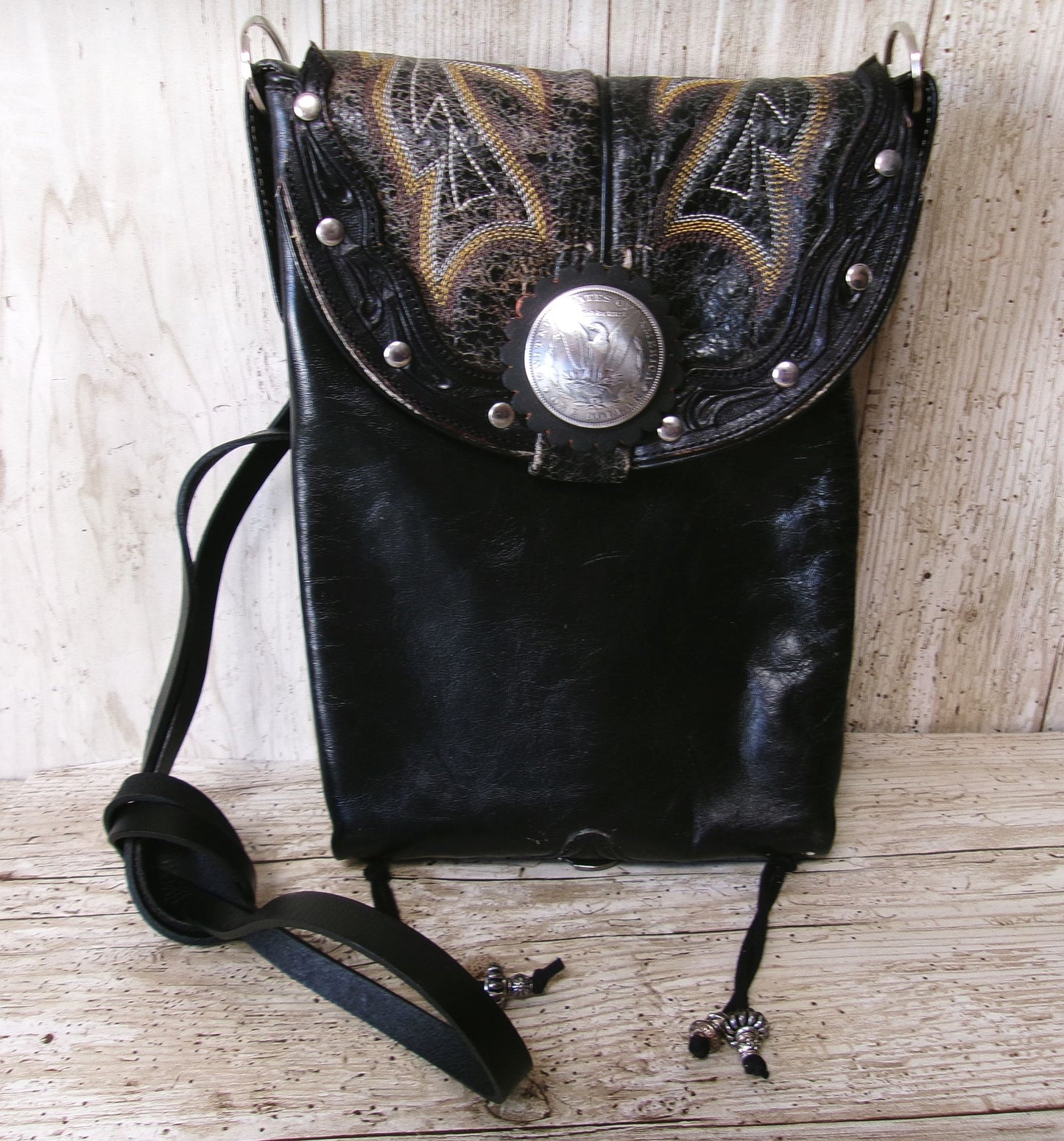 Black leather bag with decorative metal clasp on a wooden surface