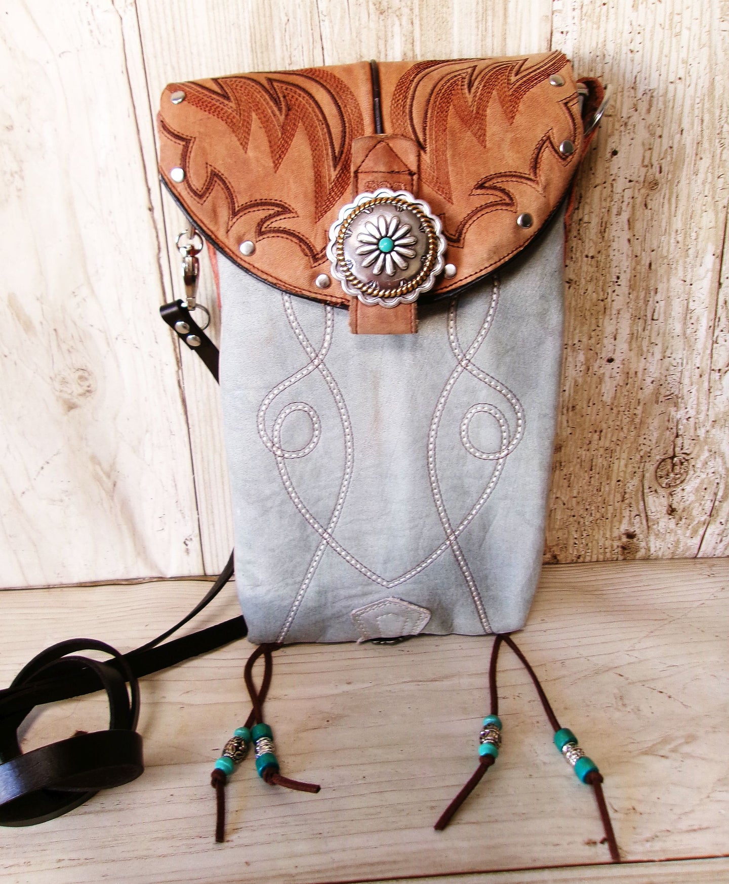 Handbag with decorative flap and beads on a wooden surface