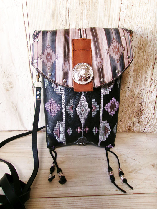 Patterned handbag with decorative strap and concho on a wooden surface