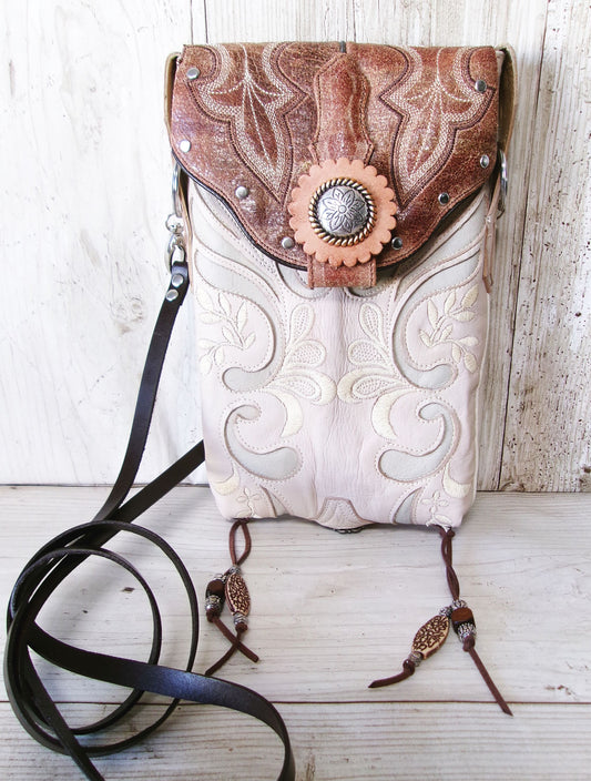 Cowboy-style handbag with intricate patterns on a wooden surface