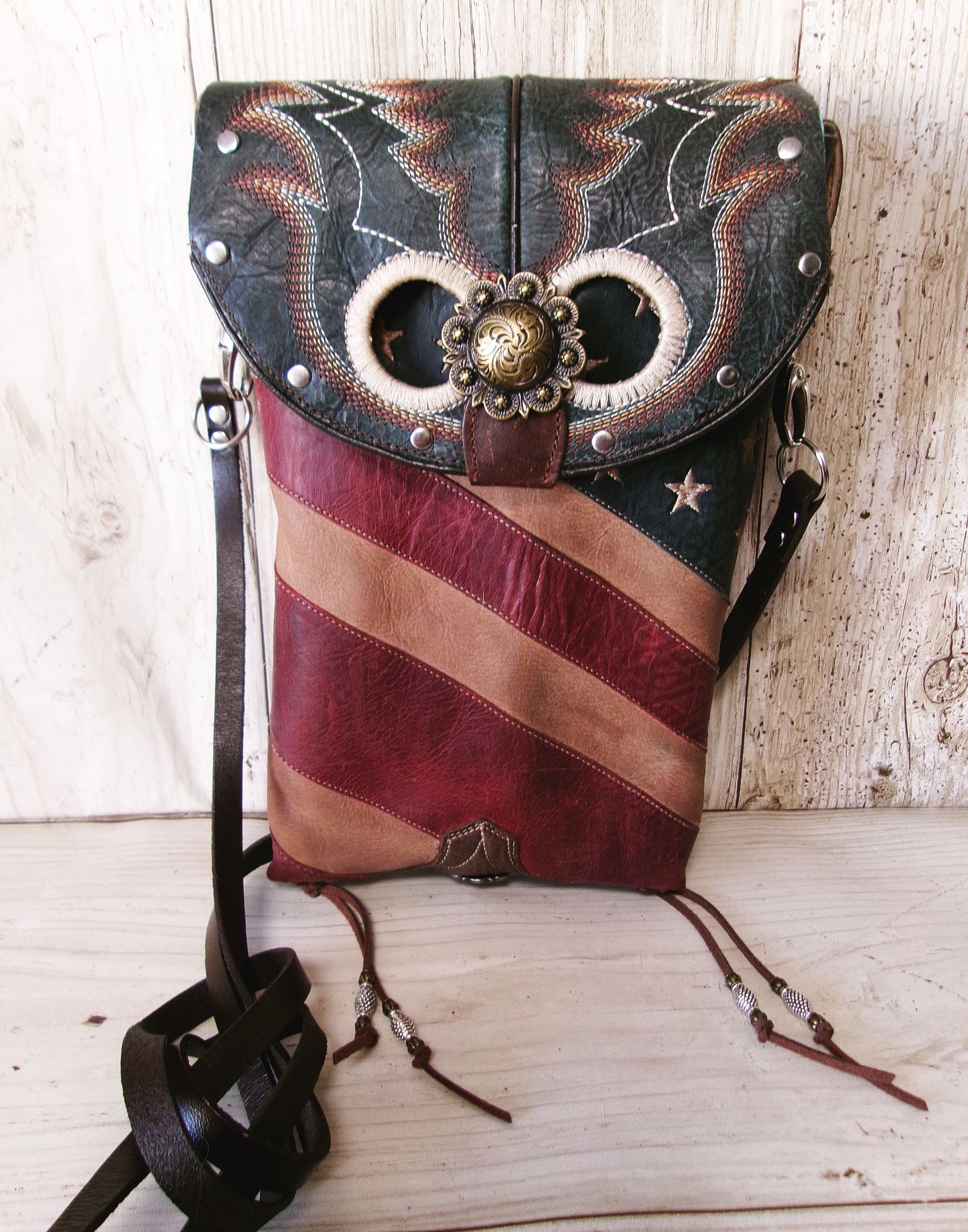 Leather bag with American flag design and decorative elements on a wooden surface