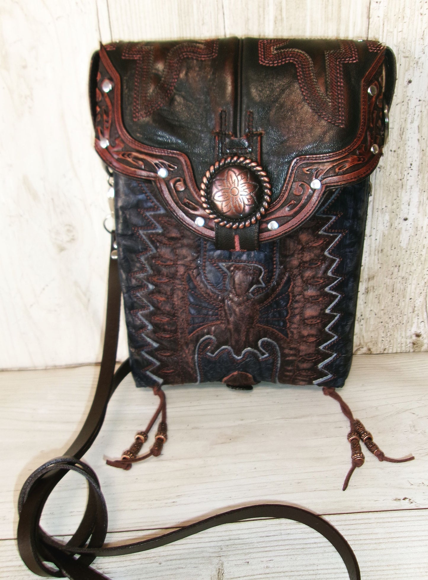 Decorative leather bag with intricate patterns on a wooden surface