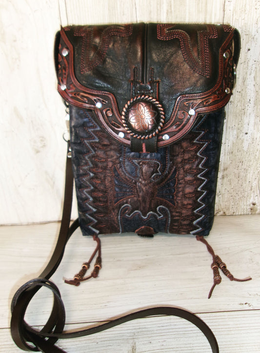Decorative leather bag with intricate patterns on a wooden surface