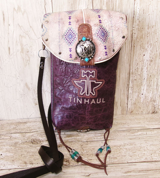 Handbag with decorative top and purple base on a wooden surface, featuring the brand 'Tinhaul'.