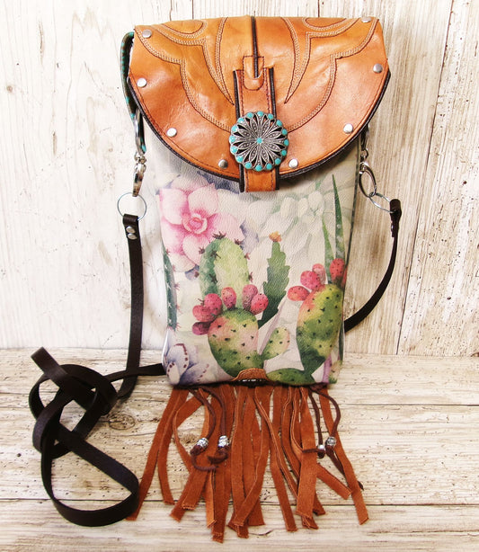 Leather backpack with cactus design and fringes on a wooden surface