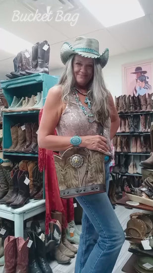 video of chris thompson showing a bucket bag in front of cowboy boots