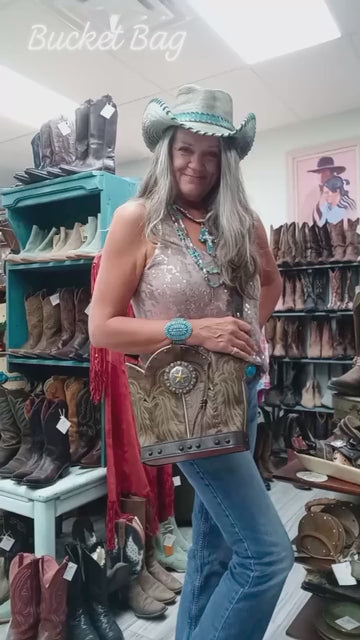 video of chris thompson showing a bucket bag in front of cowboy boots