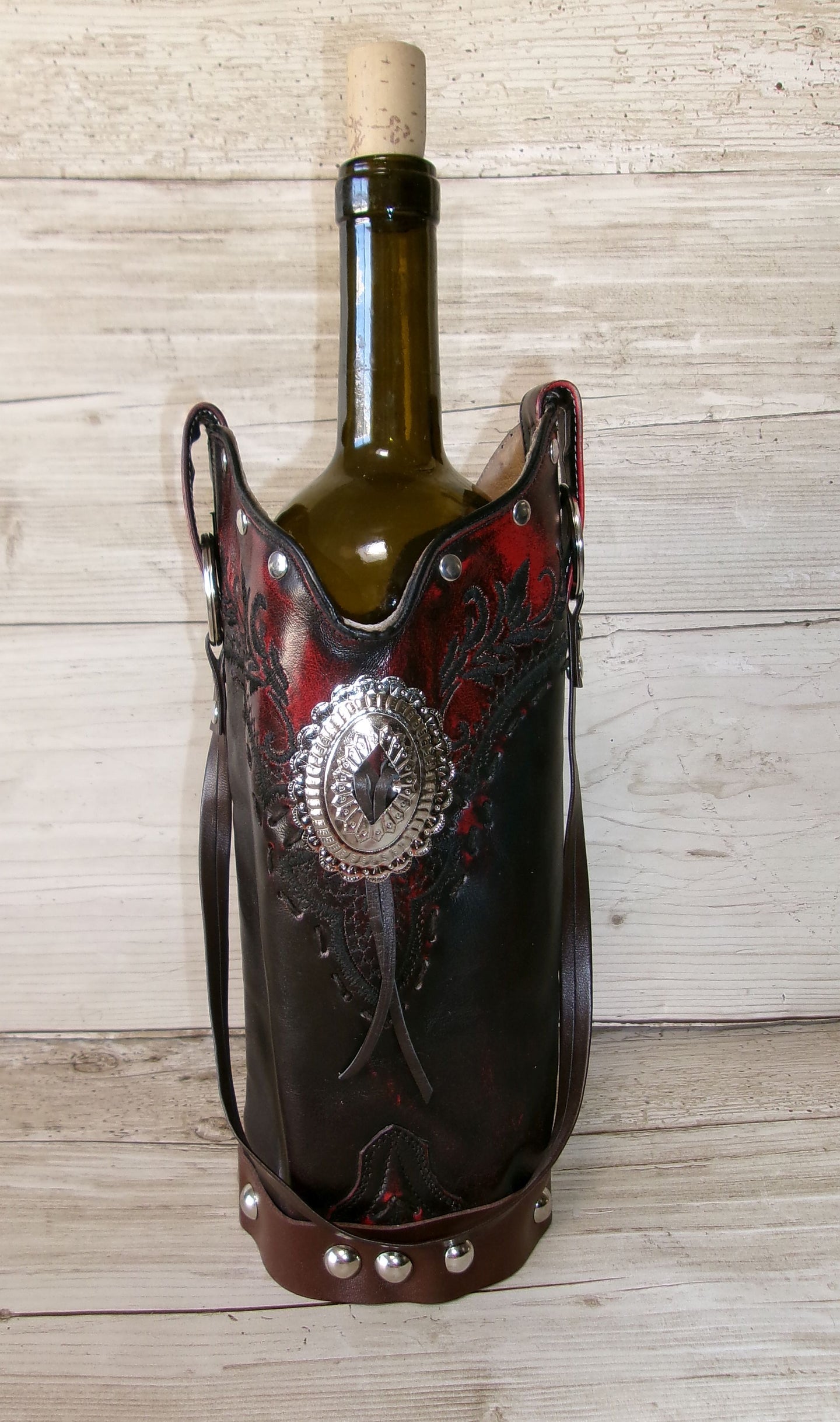 Decorative wine bottle holder with intricate designs on a wooden surface