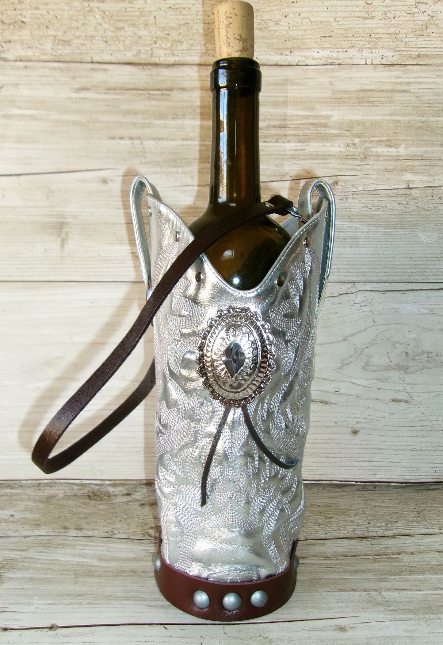 Decorative wine bottle holder with a decorative emblem on a wooden surface