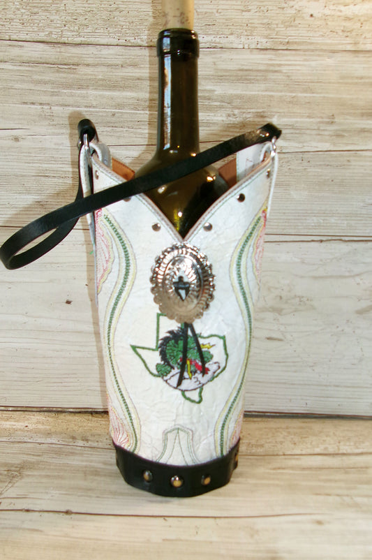 Wine bottle with decorative cover featuring a Texas map and face design on a wooden surface.