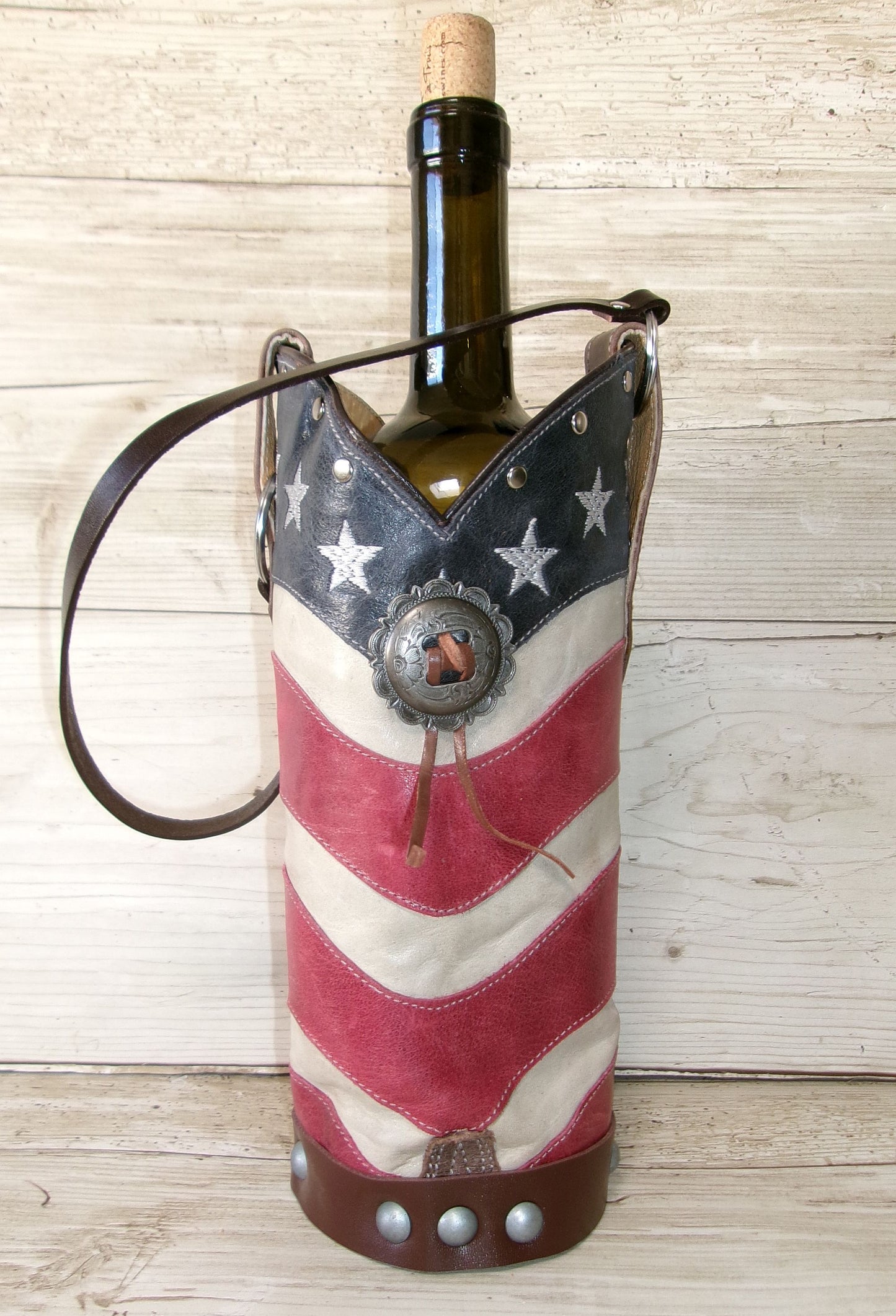 Wine bottle in an American flag-themed holder on a wooden surface