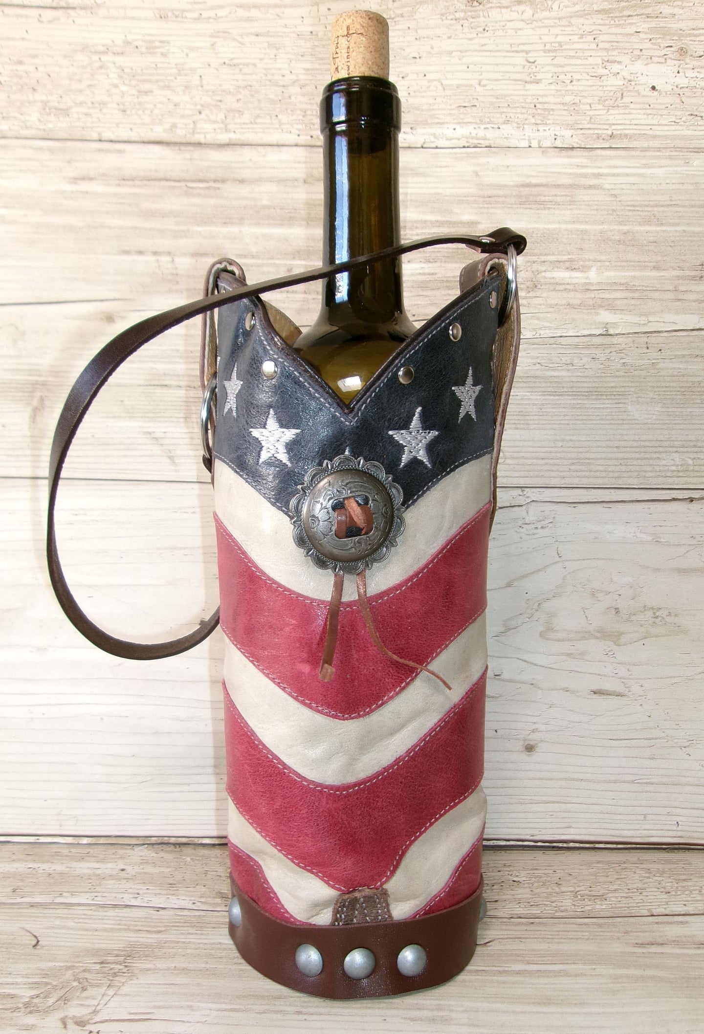 Wine bottle in an American flag-themed holder on a wooden surface