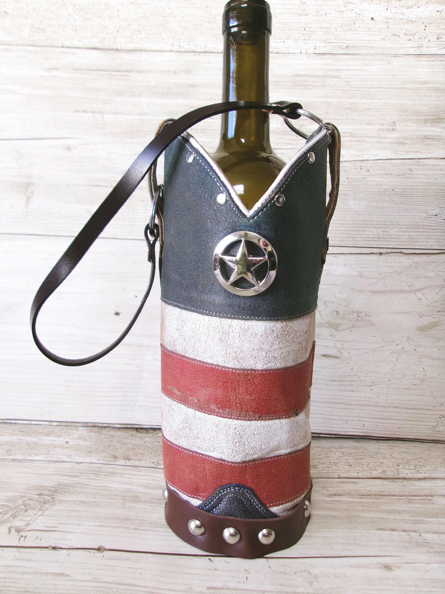Wine bottle in a decorative holder with American flag design on a wooden surface