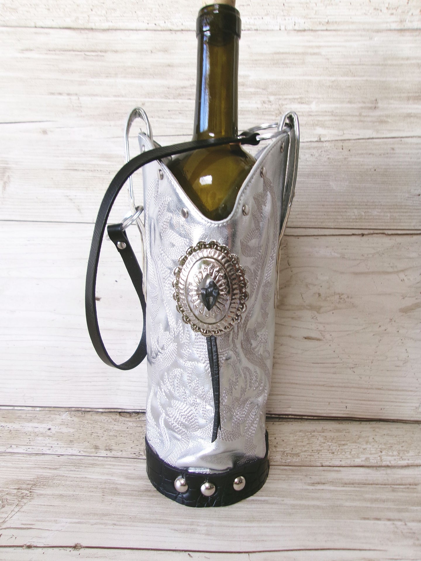 Wine bottle in a decorative boot holder on a wooden surface