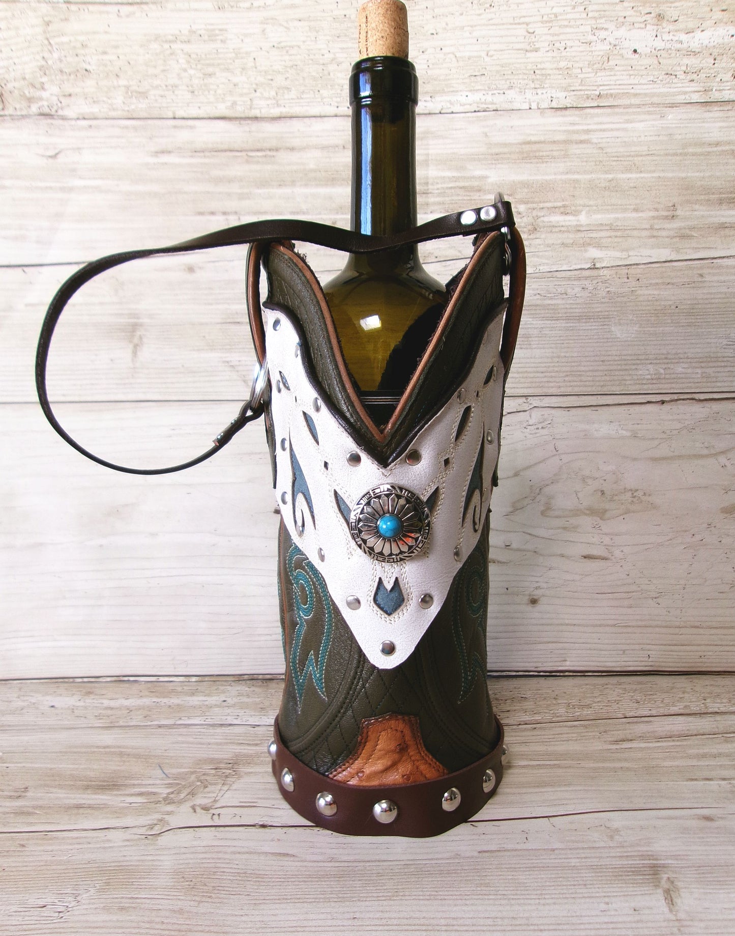 Wine bottle in a decorative cowgirl boot holder on a wooden surface