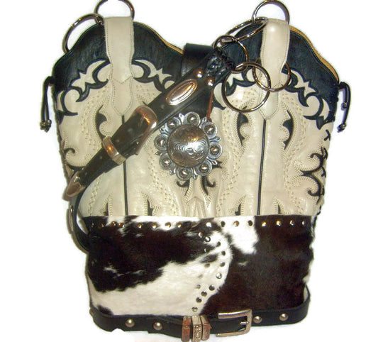 Cowhide leather handbag with decorative concho and studs on a white background