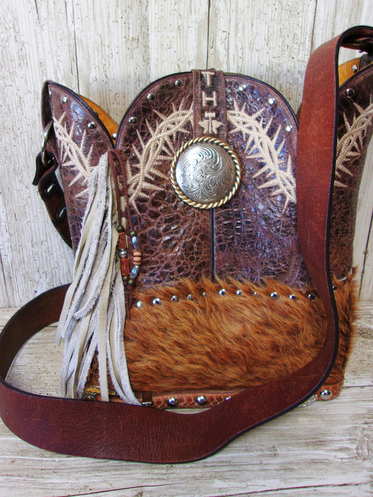 Brown leather bag with fur and decorative elements on a wooden surface