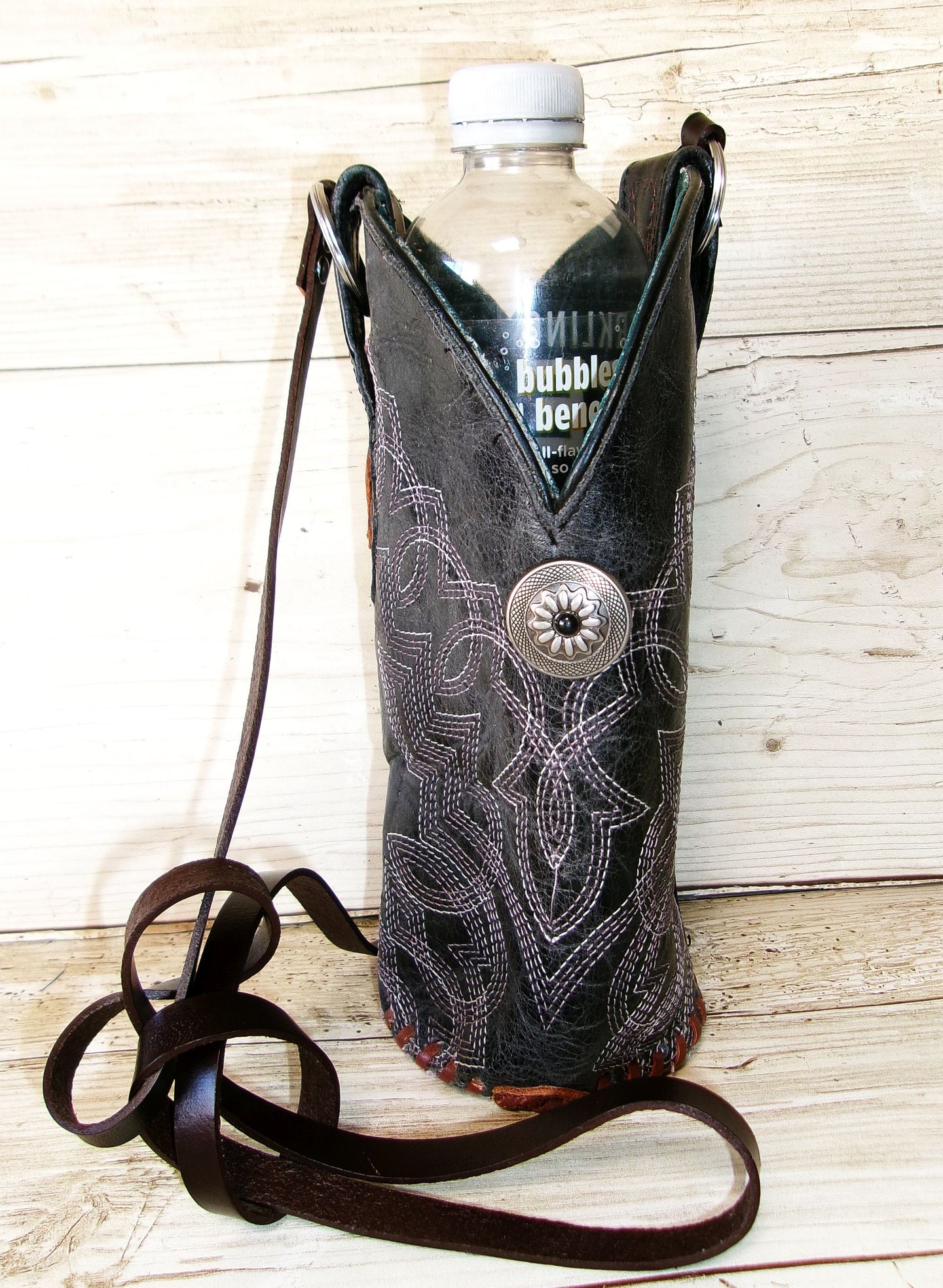 Cowboy boot-shaped bottle holder with a bottle on a wooden surface