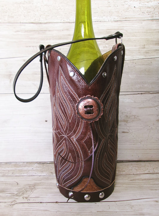 Brown leather wine bottle holder with intricate patterns on a wooden surface