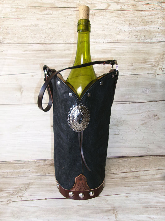 Wine bottle in a decorative black holder with metal accents on a wooden surface
