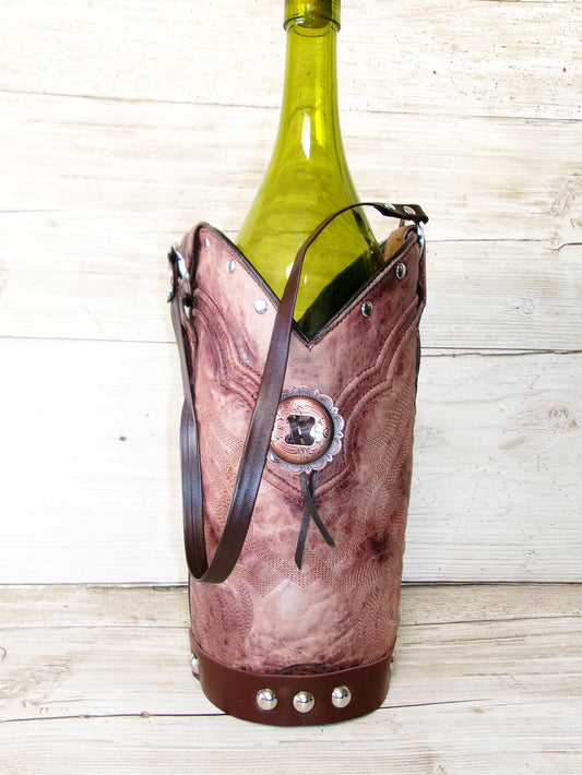 Brown leather wine bottle holder with a green wine bottle on a wooden surface