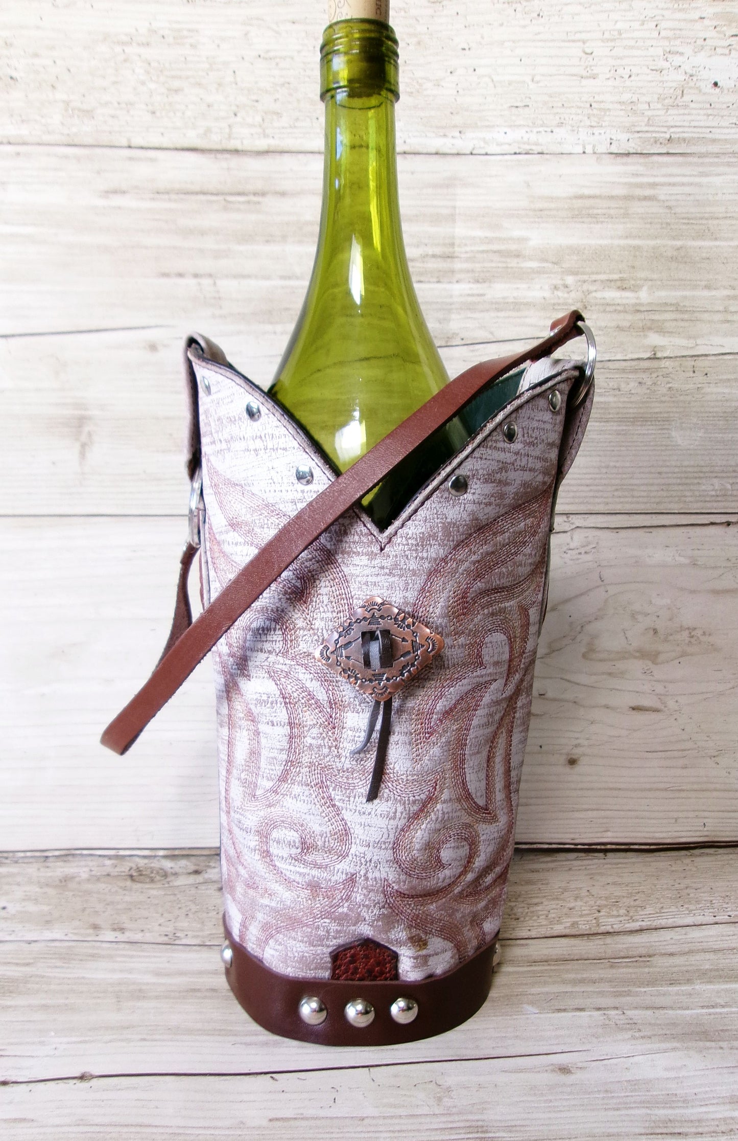 Wine bottle in a decorative holder on a wooden surface