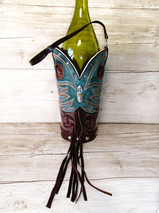Decorative bottle holder shaped like a boot with a butterfly design, holding a green bottle on a wooden surface.