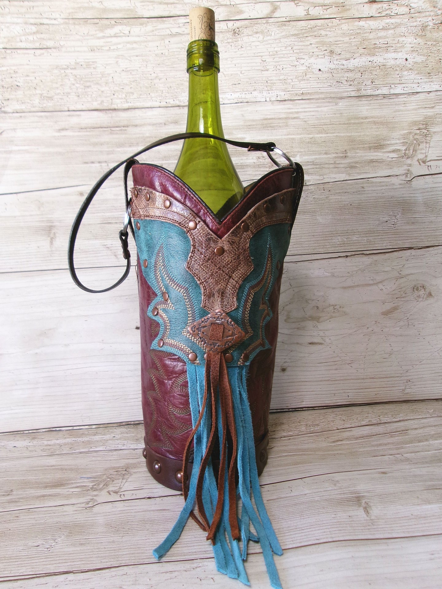 Wine bottle in a decorative leather holder on a wooden surface